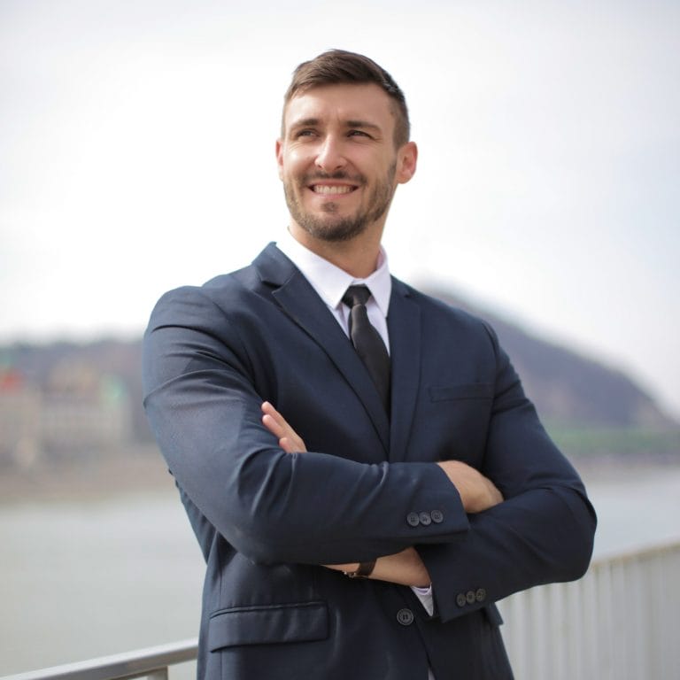 Ein Versicherungsmakler blickt erfreut in die Ferne. Symbolisch für Gebietsschutz als maxXse Partner.