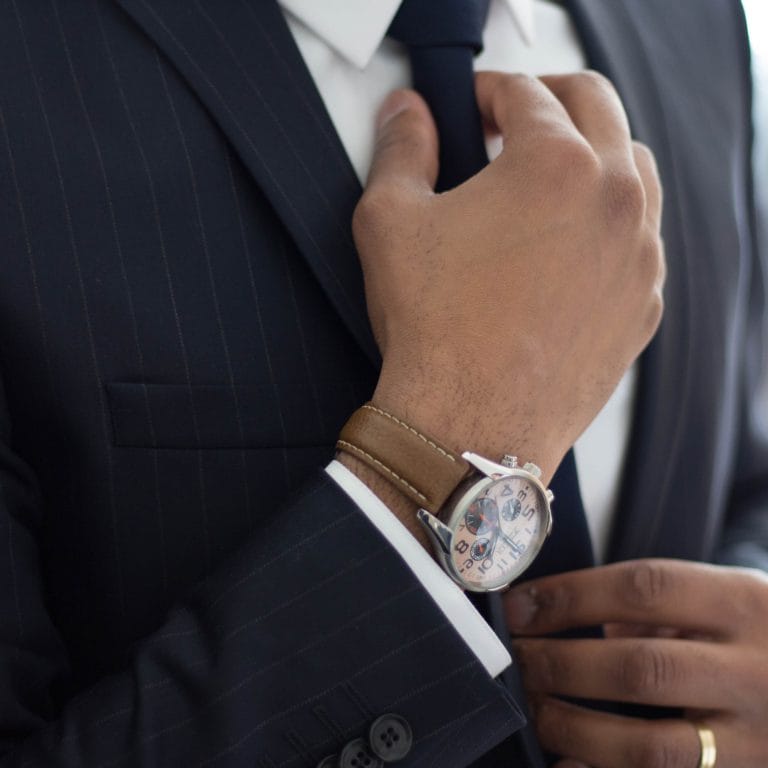 Ein Versicherungsmakler richtet sich die Krawatte. Symbolisch für Kundenverwaltung als maxXse Partner.