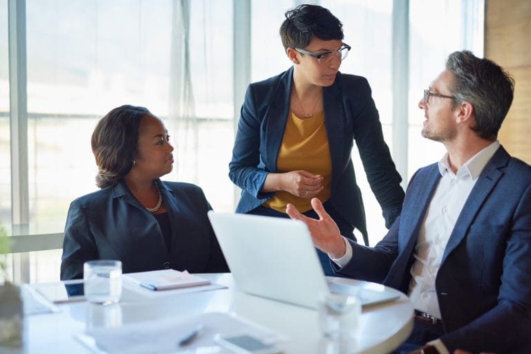 Eine Gruppe von Managern bespricht in einem Meetingraum. Symbolisiert eine private Krankenversicherung für Angestellte, etwa Manager und Gutverdiener.